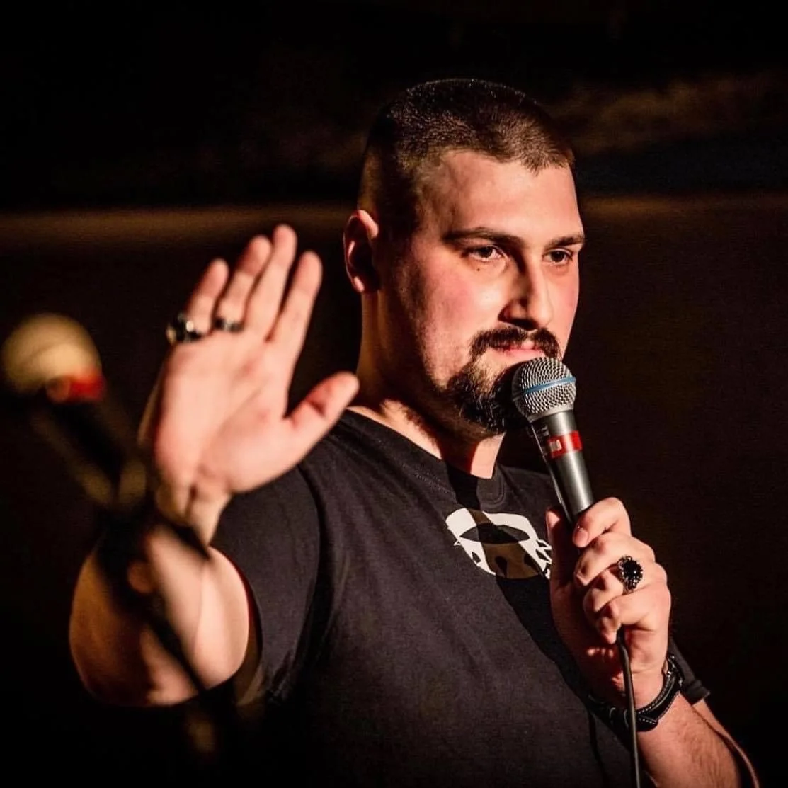 Dano Čistý počas stand-up vystúpenia s rukou zdvihnutou pri mikrofóne